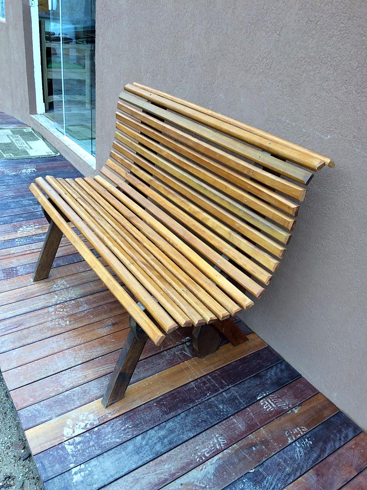 Banco de ripas de madeira com assento e encosto curvos