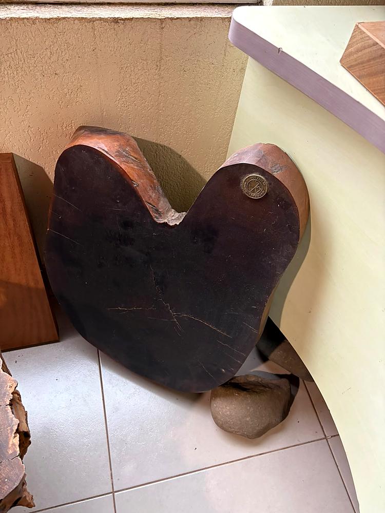 Medalhão de latão aplicado na lateral de uma peça de madeira